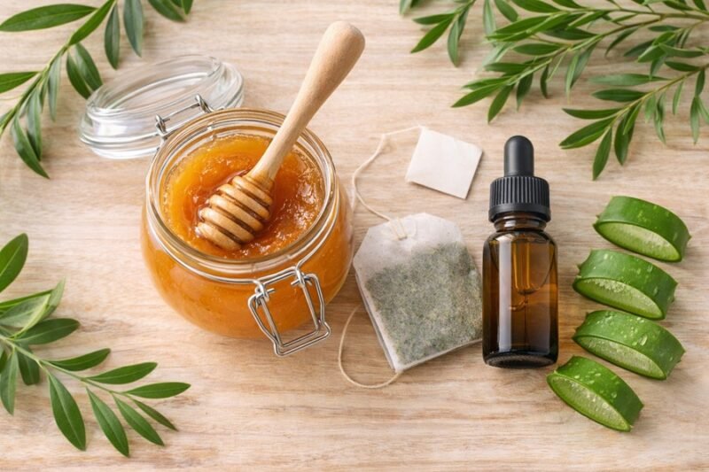 Close-up of organic ingredients for natural acne treatment including tea tree oil and honey.